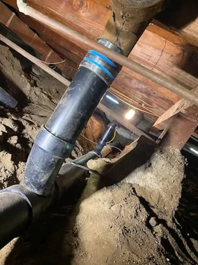 Corroded underground sewer pipe with blue repair bands during excavation work
